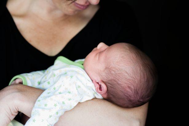 Close up of mother holding newborn baby